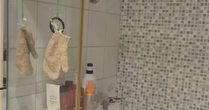 A cleaned Korean shower area with white tiles, mosaic feature wall and a linear floor drain