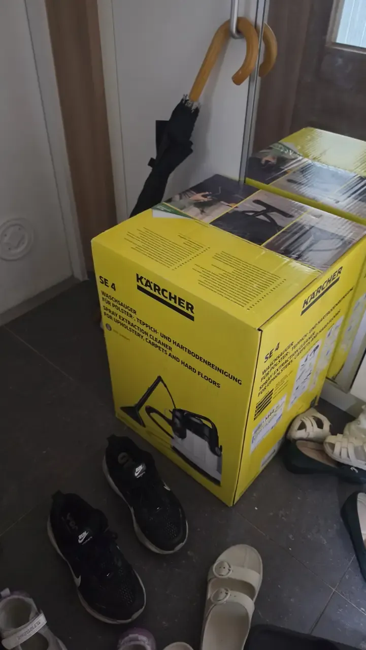Two Kärcher SE 4 spray-extraction cleaner boxes standing in a flat's entrance hall