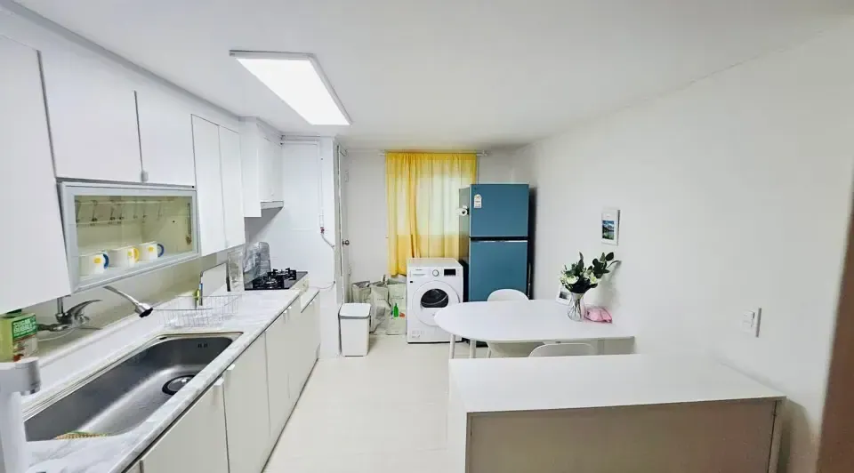 A shared kitchen with a fridge, sink and worktop