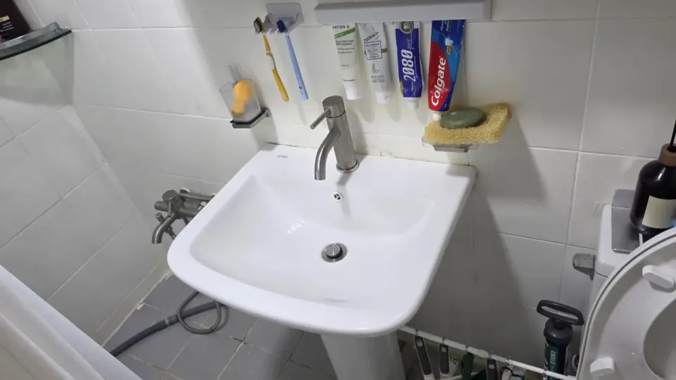 Close-up of a single-lever mixer faucet on a pedestal washbasin in a Korean bathroom