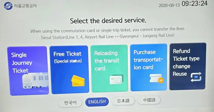 A Seoul subway ticket machine showing its English menu — single journey ticket, reloading the transit card, purchase transportation card — with the date 2026-08-13 on screen